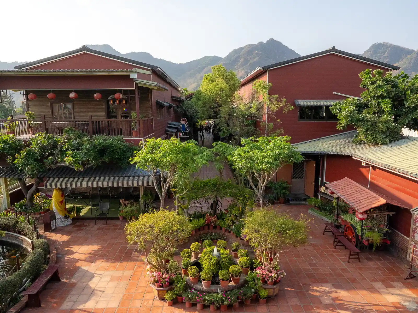 The courtyard garden and red barns of Meinong Folk Village are seen below.