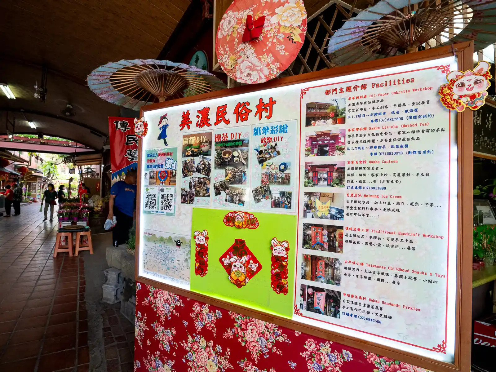 A signboard lists the various DIY activities and main attractions of the Meinong Folk Village.