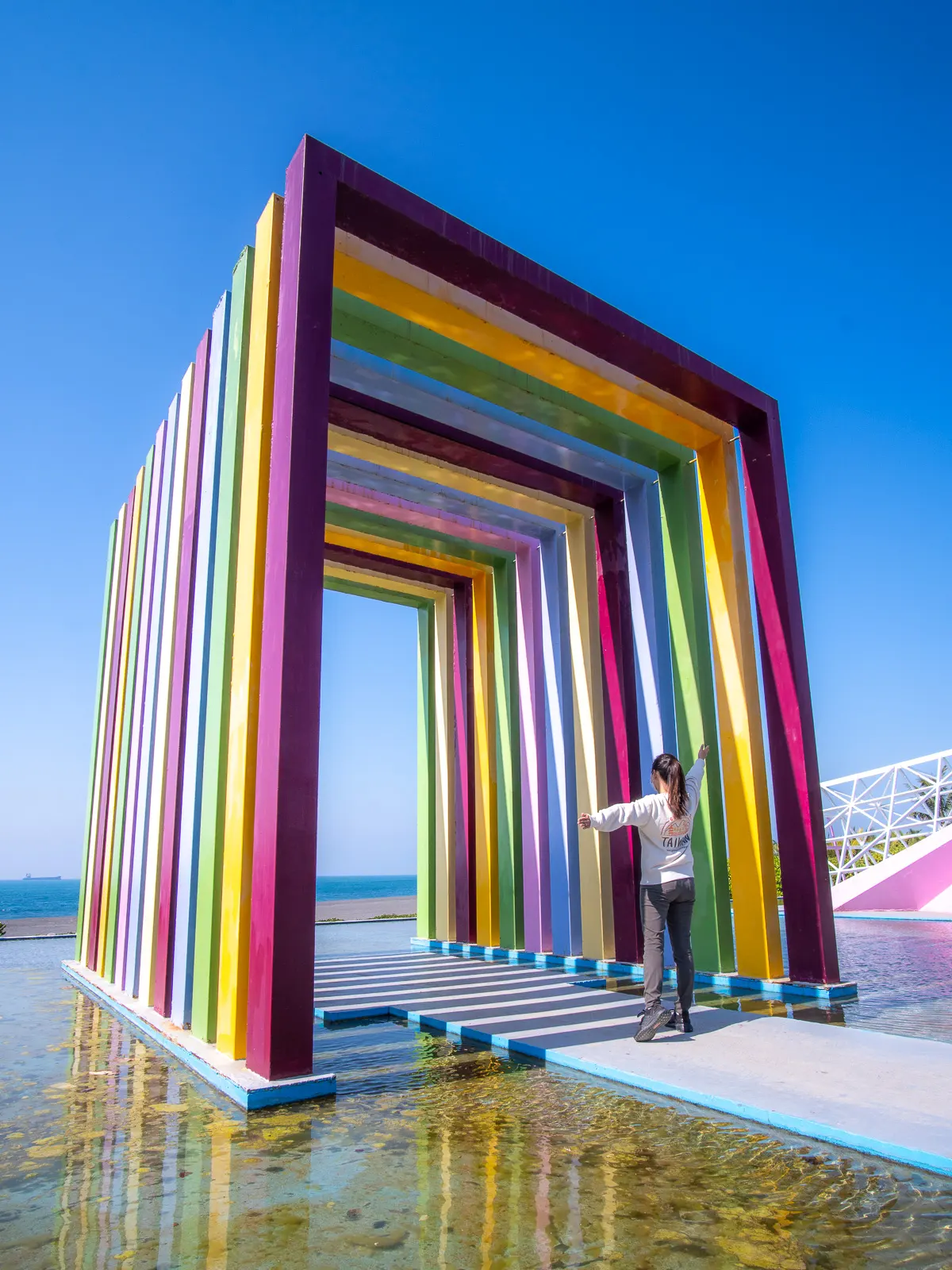 A tourist stands in front of the Rainbow Church and poses.