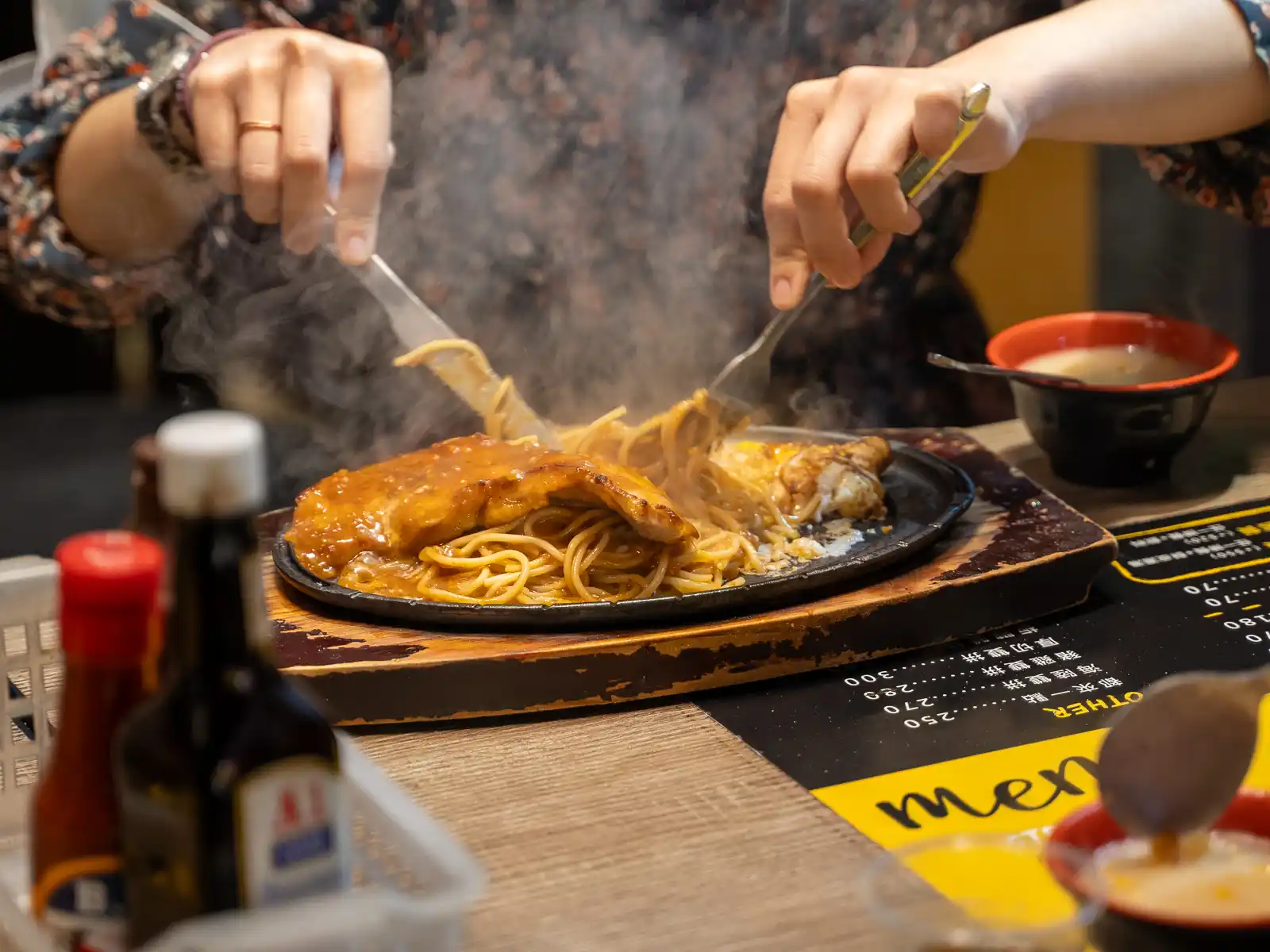 Someone is enjoying a sizzling chicken steak.