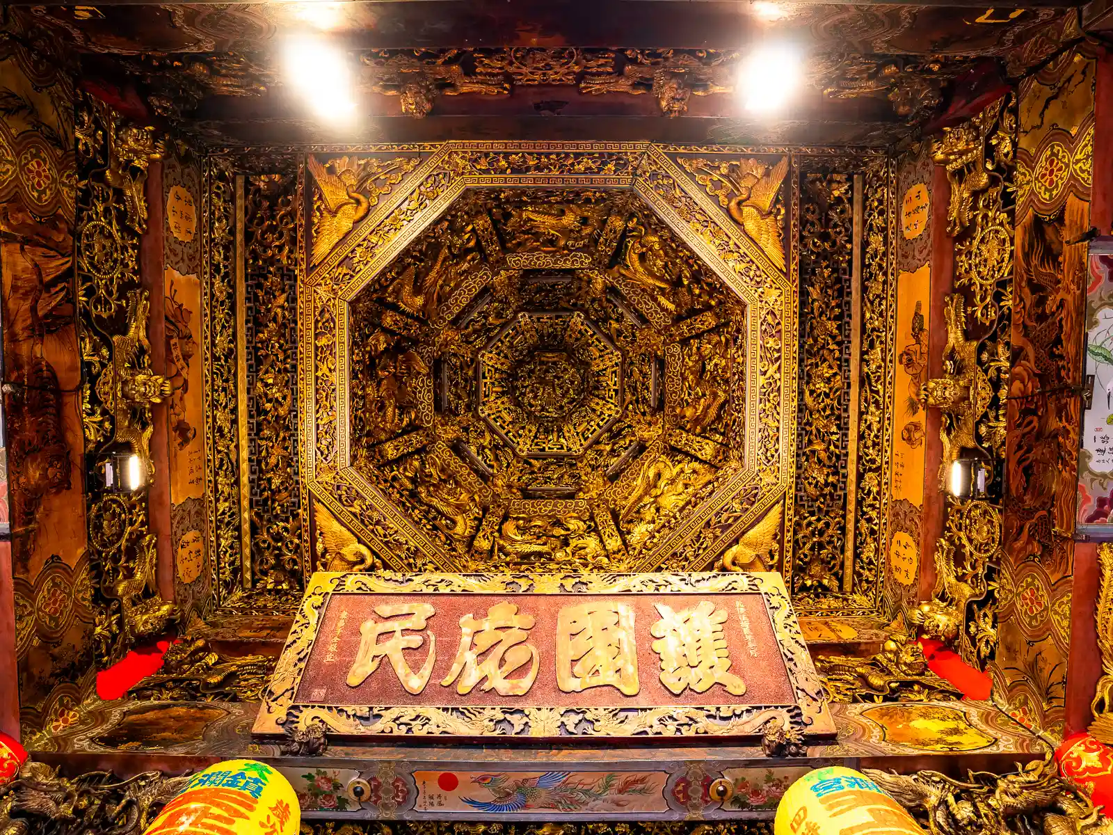 An exquisitely detailed painted gold ceiling can be seen.