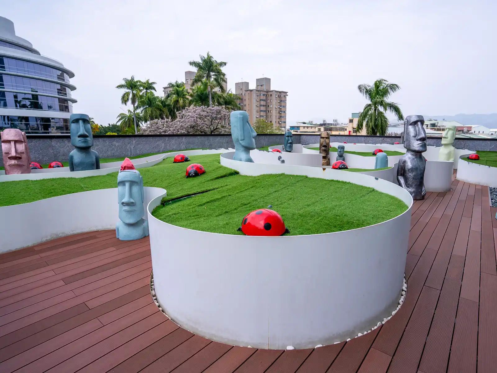 The rooftop garden features fake grass, ladybugs, and head statues like the ones from Easter Island.