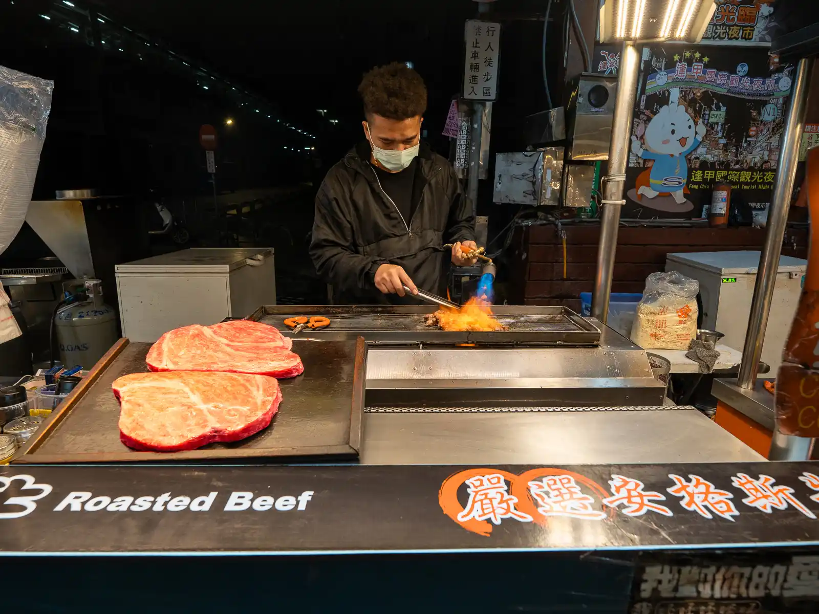 A night market vendor prepares a beef steak.