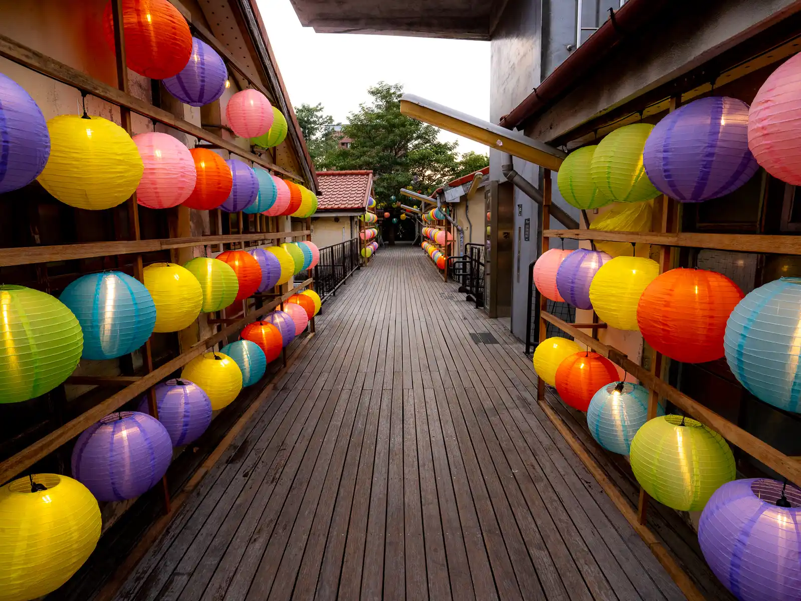 The elevated walkways connecting the buildings of Shenji New Village are decorated with colorful paper lanterns.
