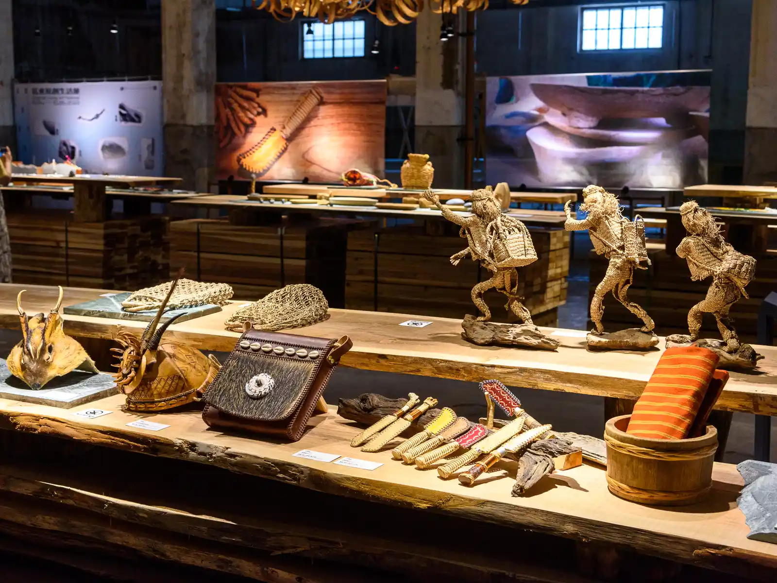 Crafts made from woven rattan, including knives and sculptures are on display inside an exhibition space.