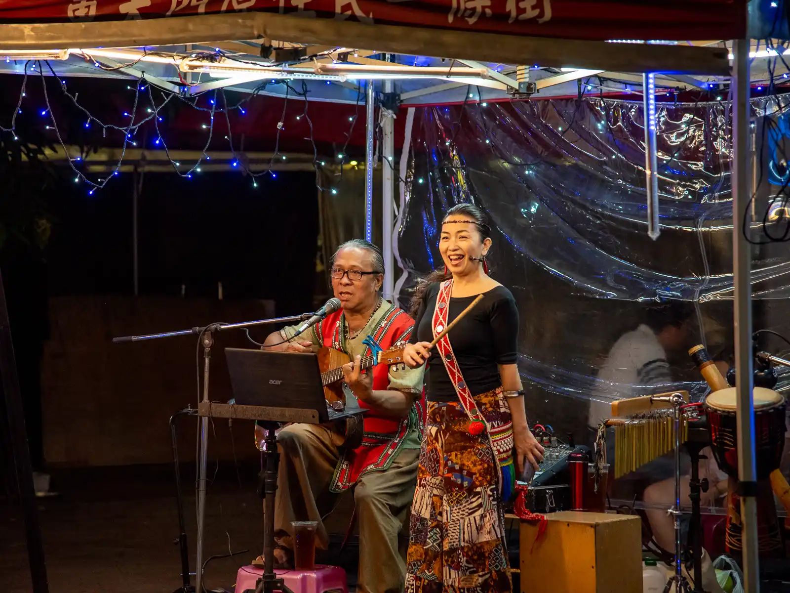 Indigenous performers perform using a mixture of guitar and local instruments.