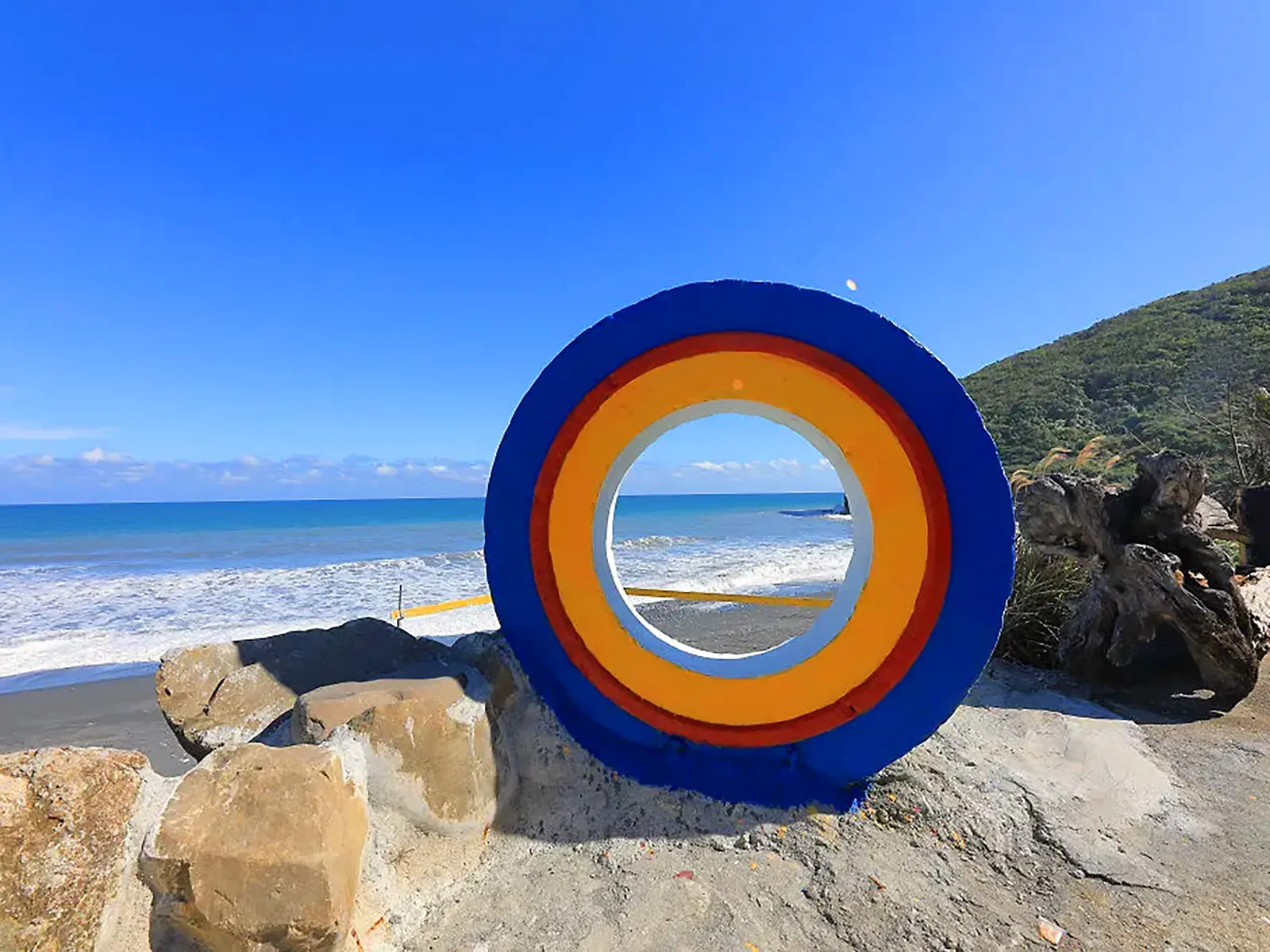 A colorful donut-shaped sculpture overlooks Niushan Beach.