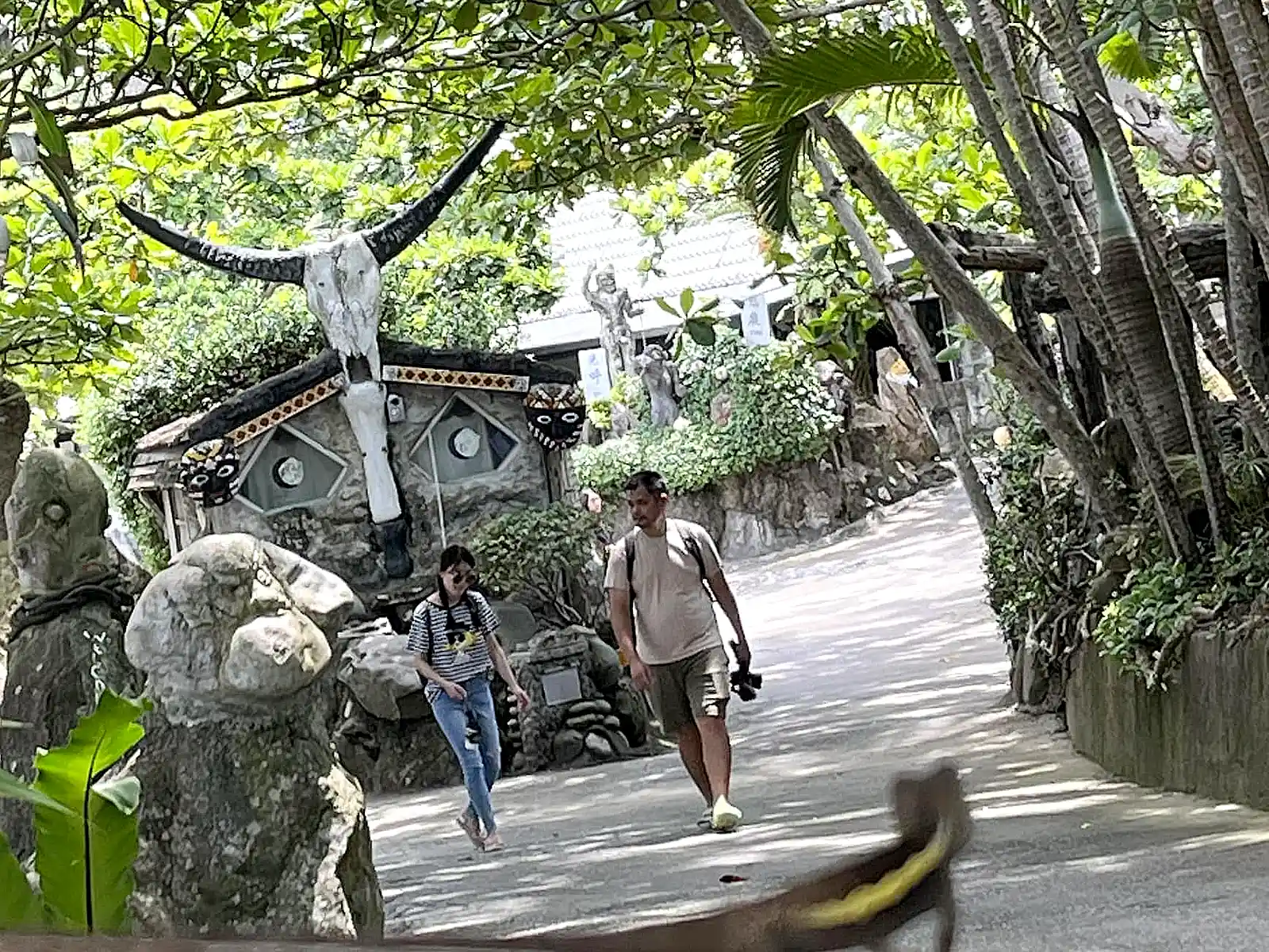 Two tourists walk through the entrance to Niushan Huting Recreation Area.