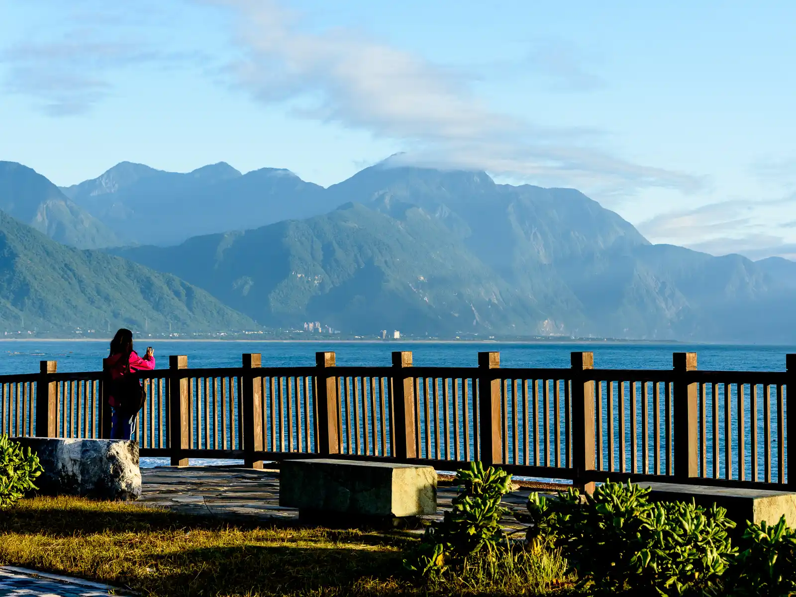 The towering mountains of Taroko National Park can be seen glowing in sunlight across the water from Qixing Beach.