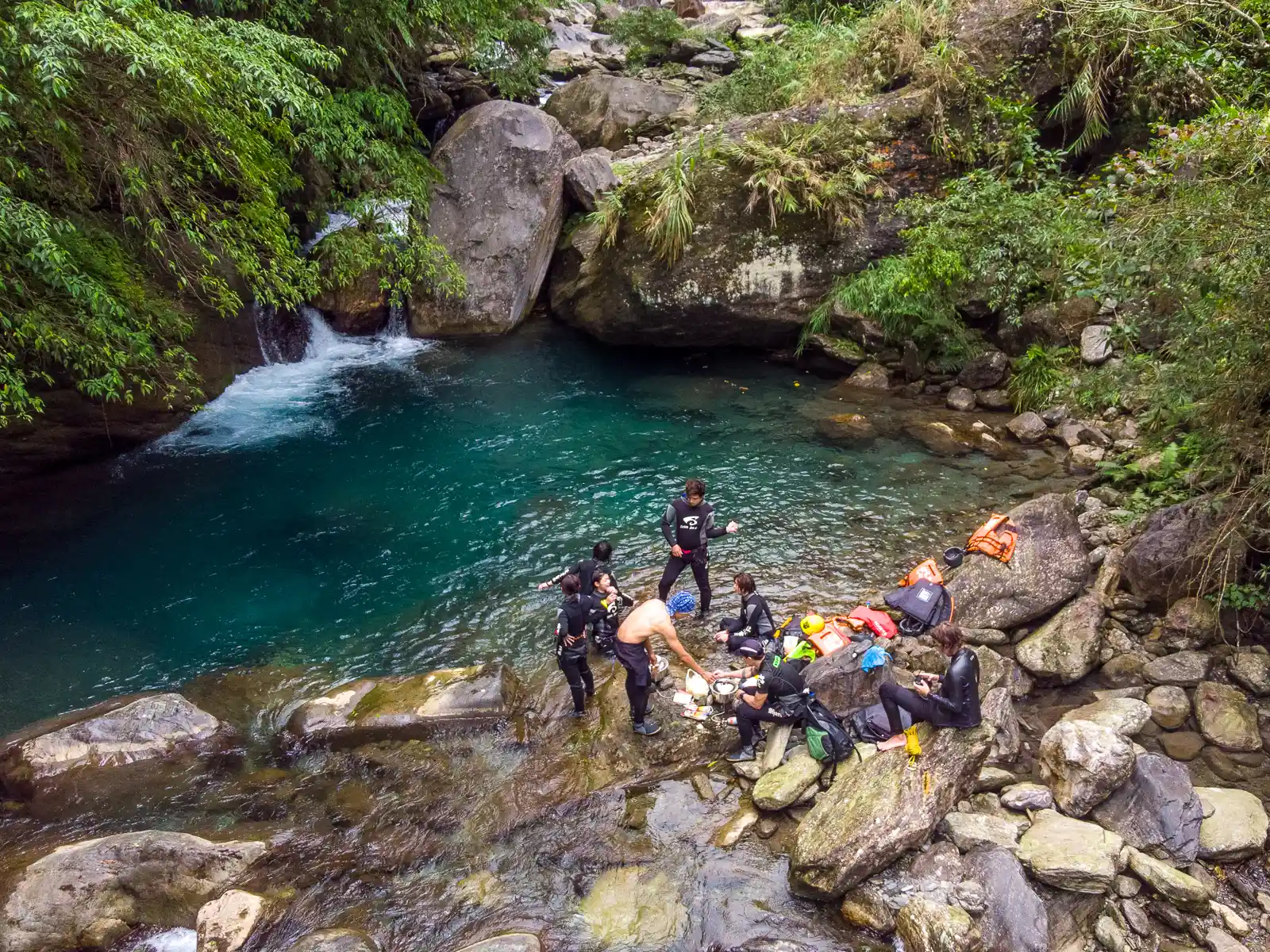 A private tour cooks noodles by one of the pools in the river.