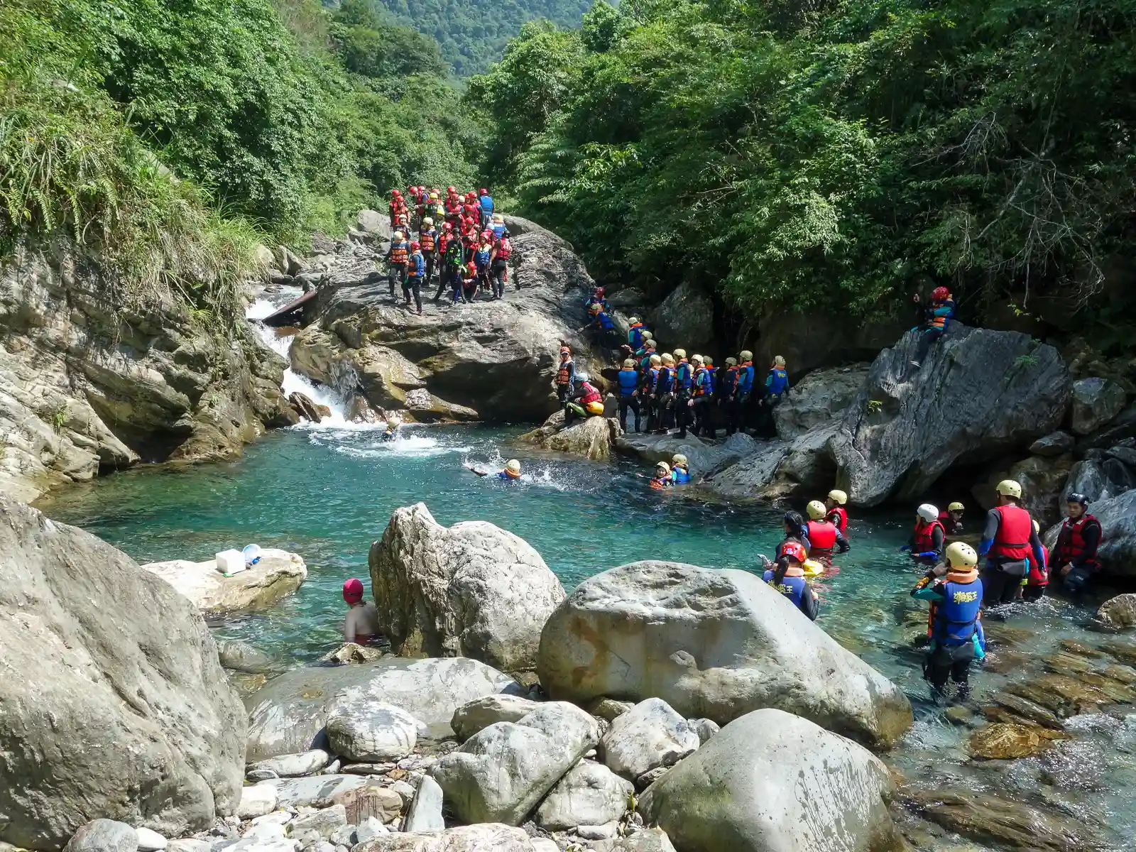 Members of several tour groups surround the first pool waiting for their turn to jump into the water.