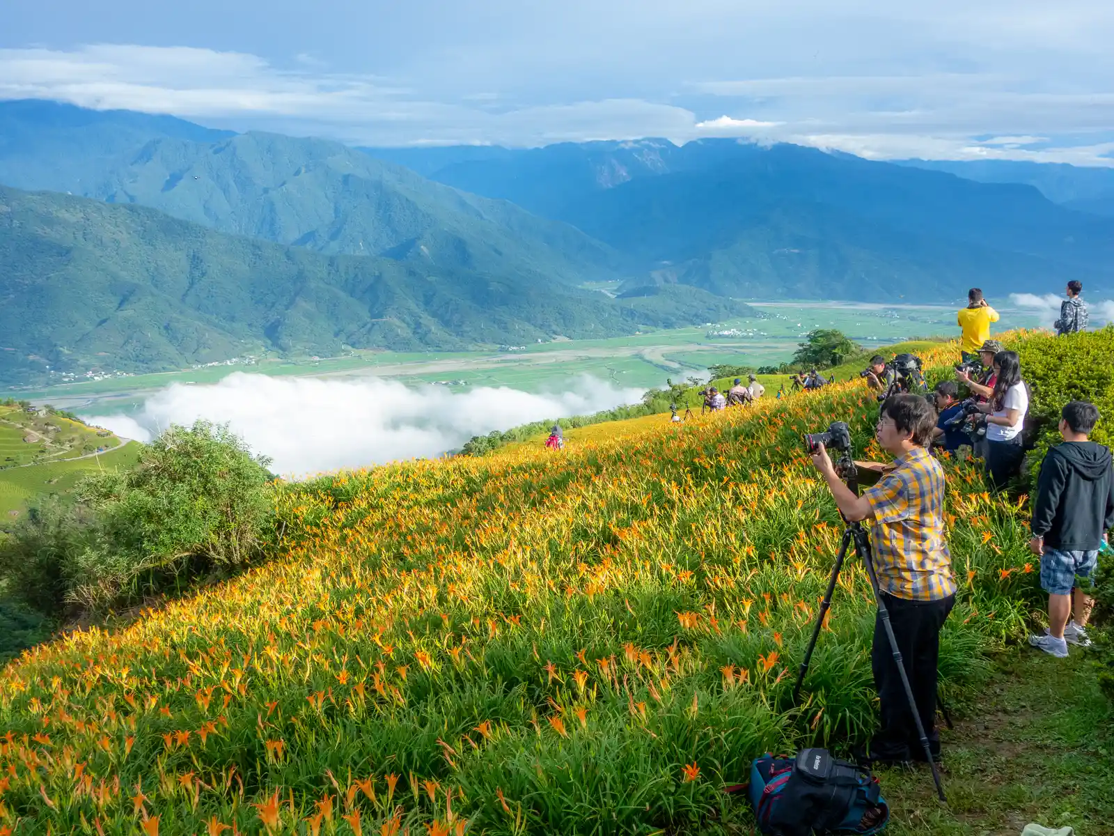 Photographers take photos of a sea of clouds hovering over the East Longitudinal Valley below.