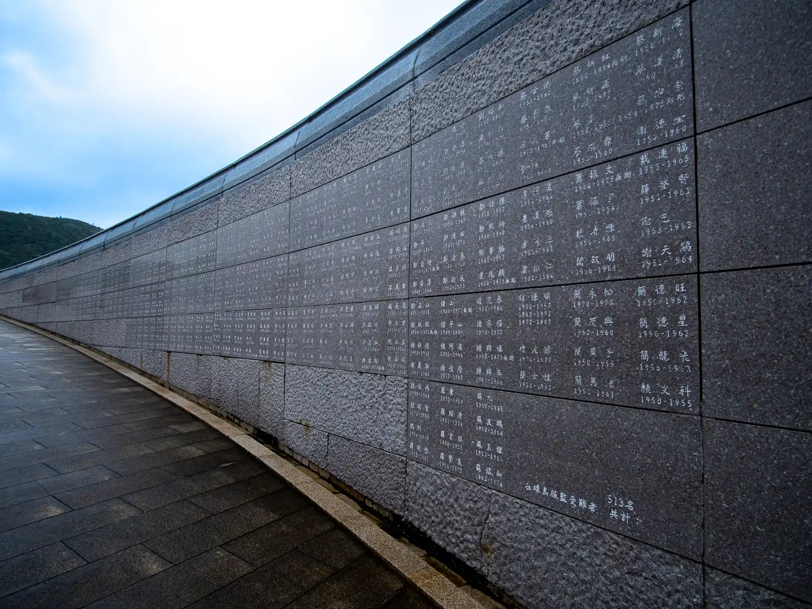 Hundreds of names along with birth and death dates are engraved on a long circular wall.