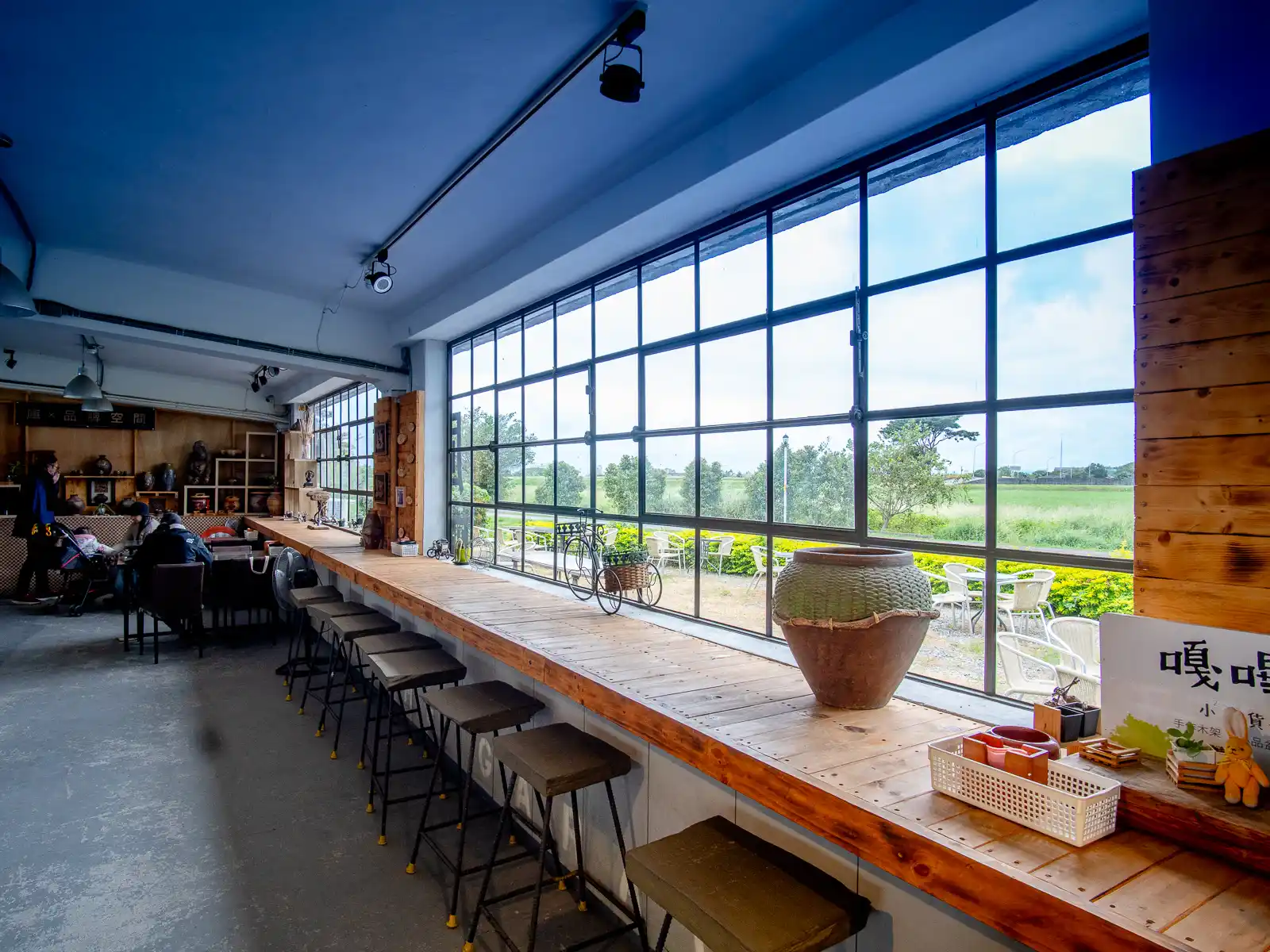 A row of windows at a cafe looks out onto rice fields.