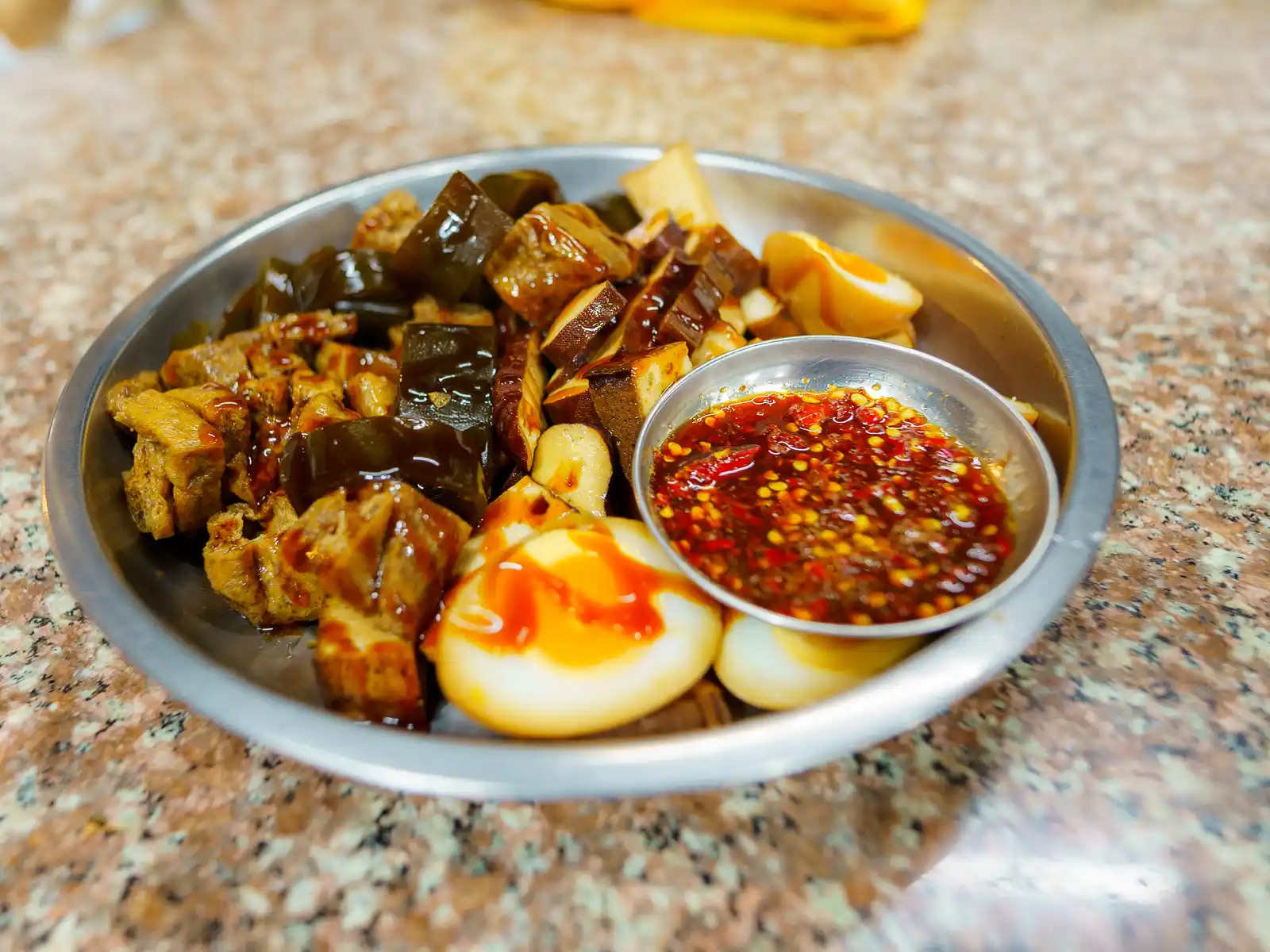 A classic sampler dish features egg, kept, tofu skin, and bean curd topped in thick soy sauce.