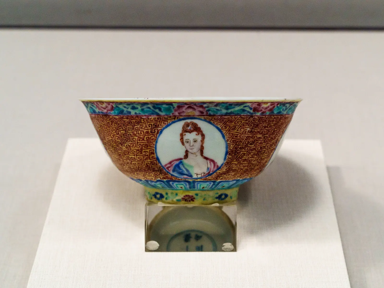 A porcelain bowl with ornate patterns and a central portrait of a woman.