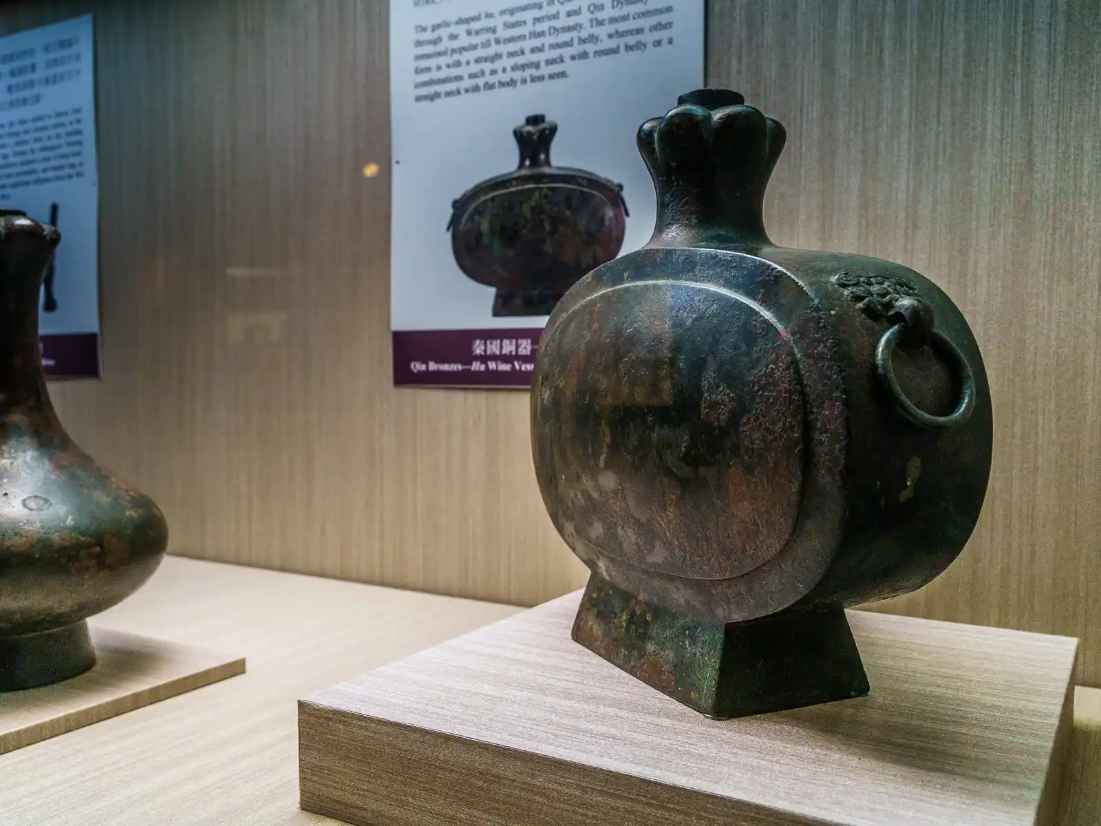 An intricately designed wine vessel with a circular body and handle on display.