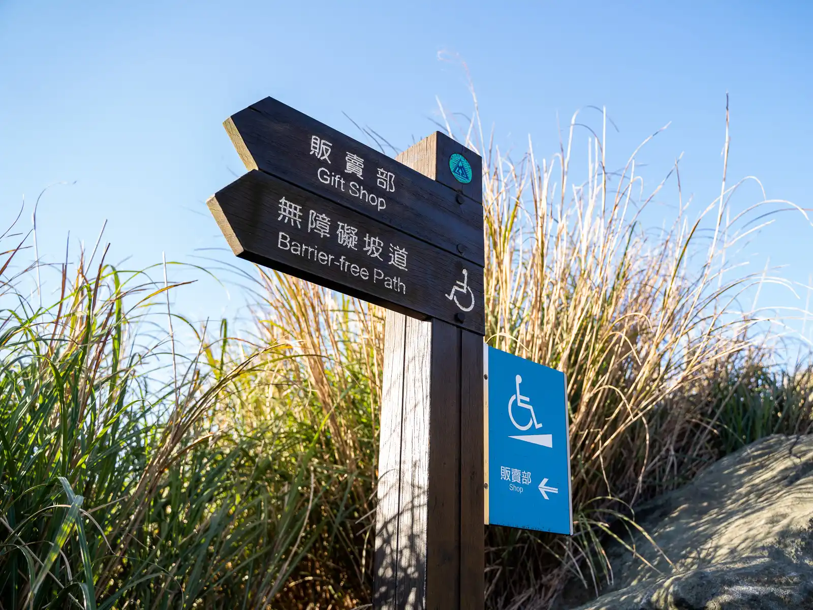 A signpost displays the way to the gift shop and notes the direction of the barrier-free path.