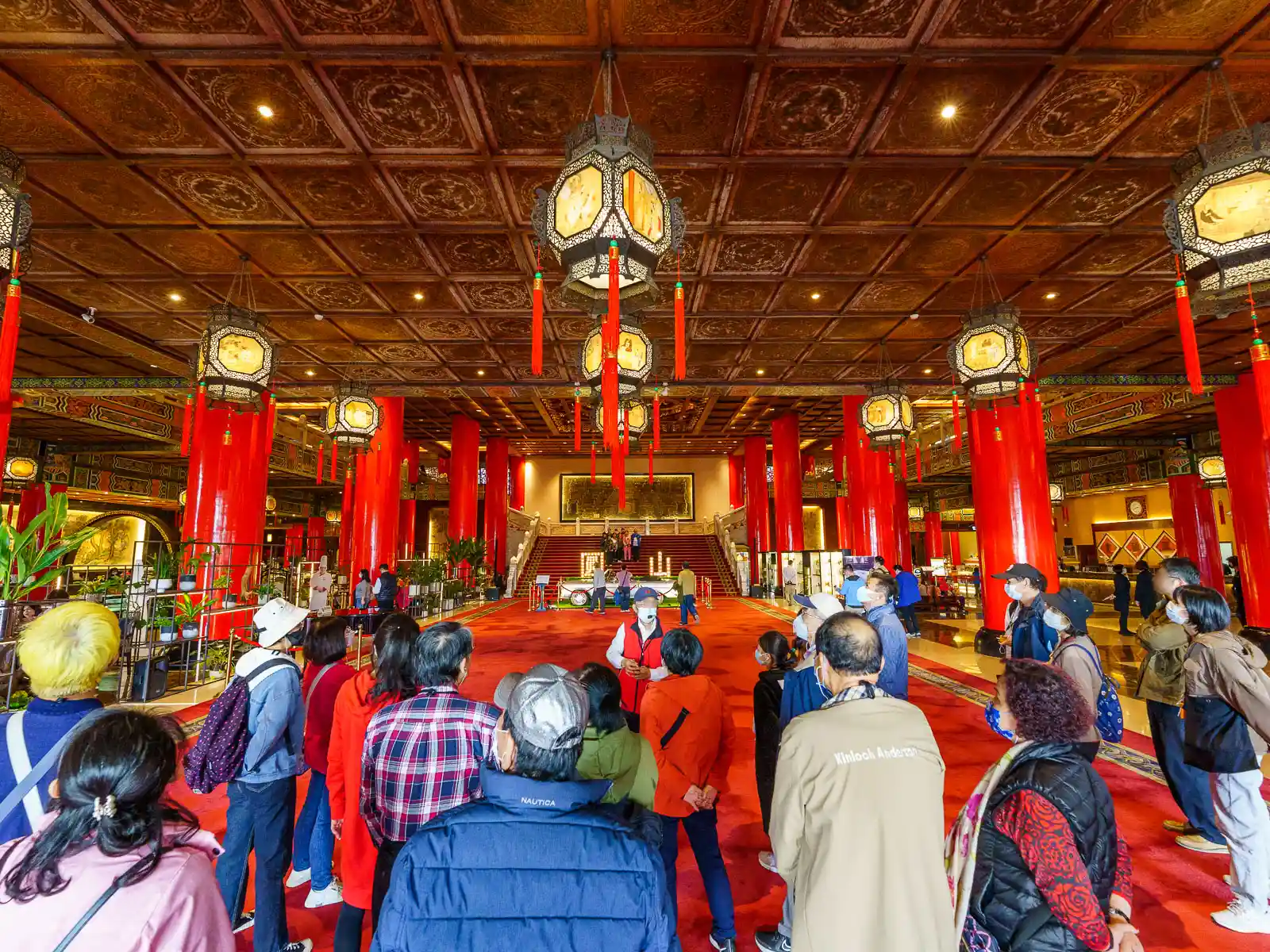 A tour guide speaks to a group of tourists at the entrance to the lobby of the Grand Hotel.