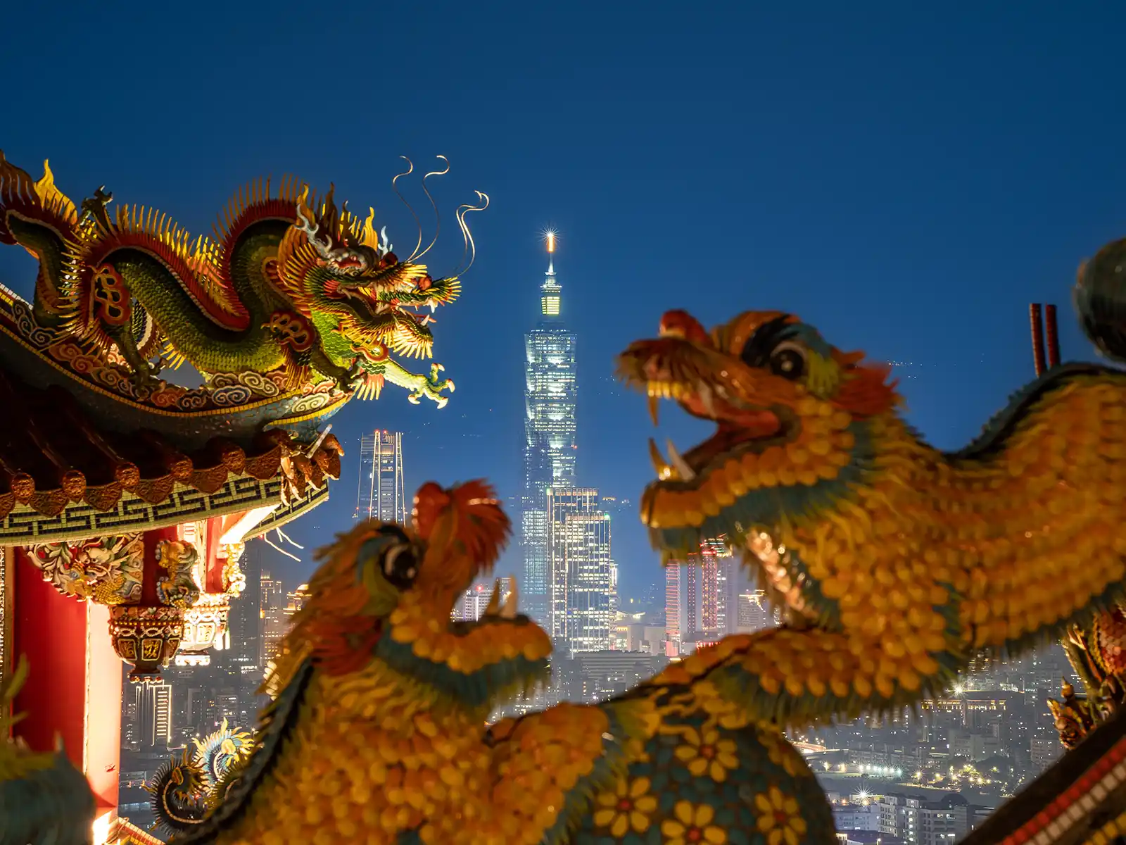 Taipei 101 can be far seen in the distance in the gap between several dragon statues on the temple's roof.