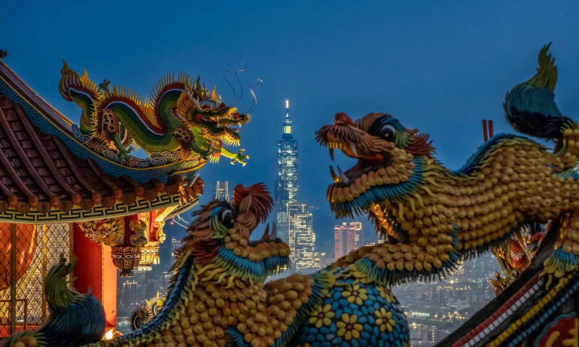 Taipei 101 can be far seen in the distance in the gap between several dragon statues on the temple's roof.