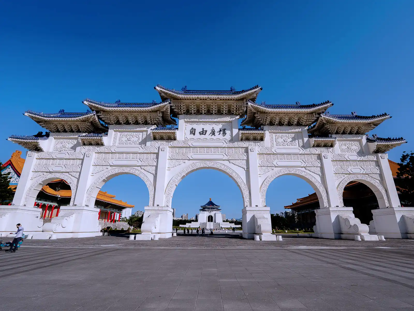 A massive five arch gate with several levels of blue roofs stands at the entrance to the complex.