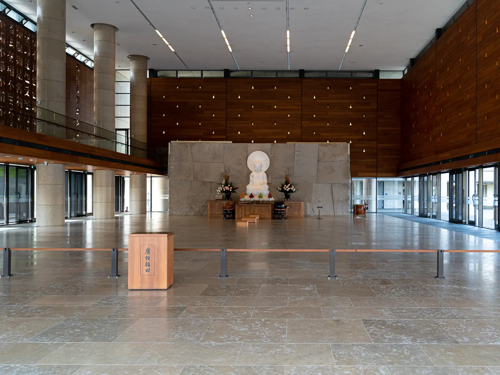 Spacious interior with Buddha statue and wooden panels.