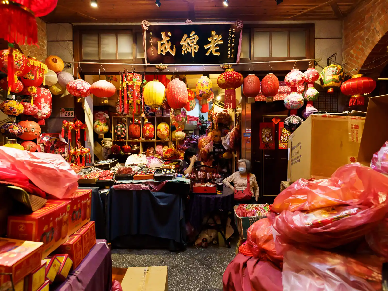 A busy stall sells red lanterns and traditional decor.