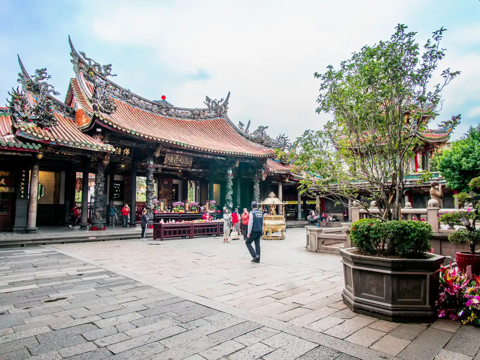 Traditional temple courtyard with people and intricate architecture.