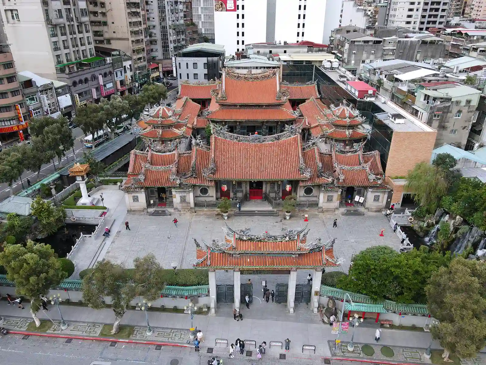 Aerial view of a traditional temple amidst urban buildings.