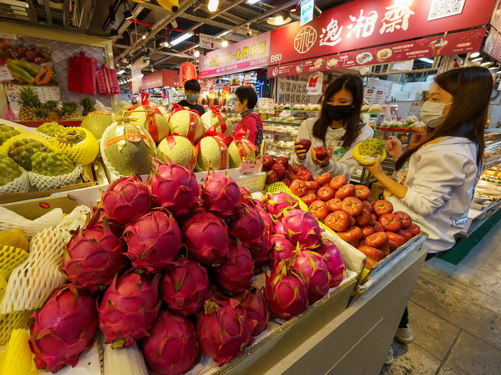 Assorted fresh fruits on display at a vibrant market stall.