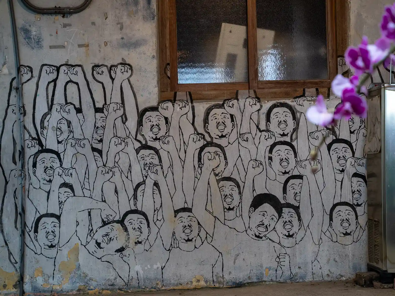 A mural consisting of dozens of identical figures raising their fists and screaming.