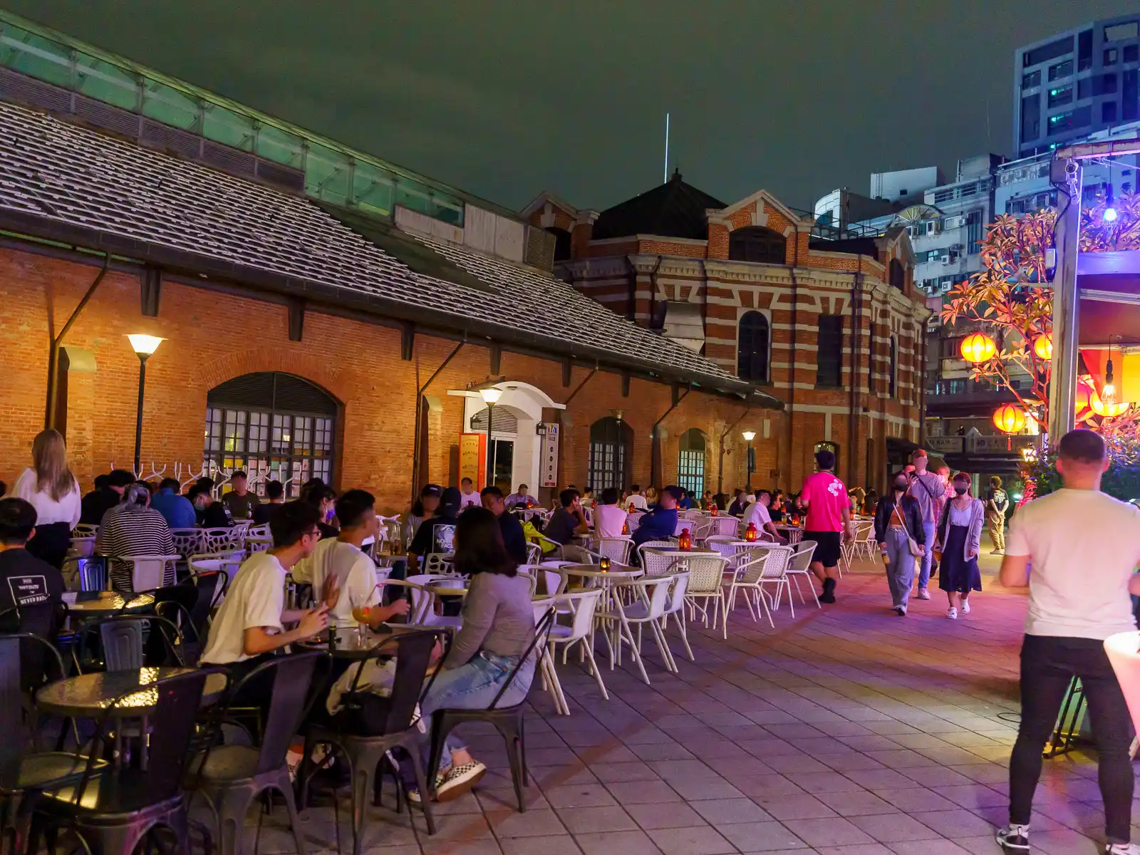 People socializing in an outdoor cafe at night.