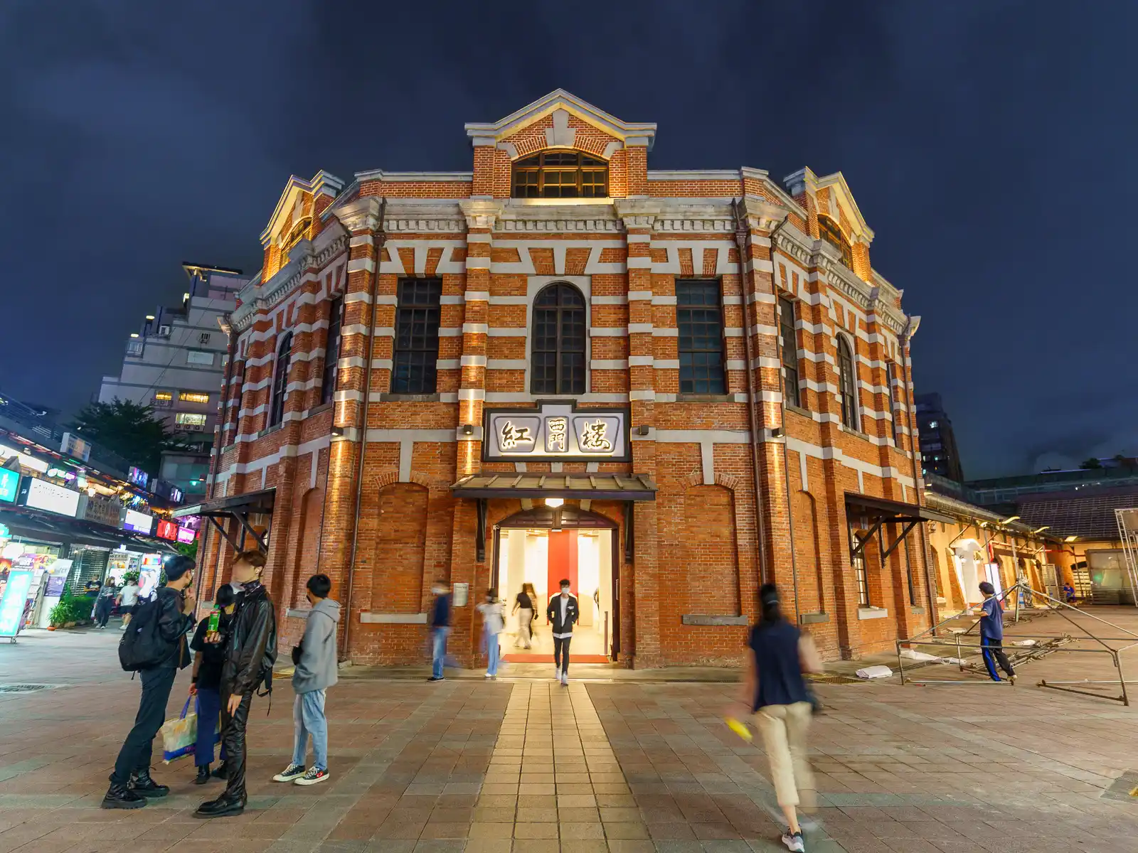 Historical red brick building at dusk with people milling around in Taipei.