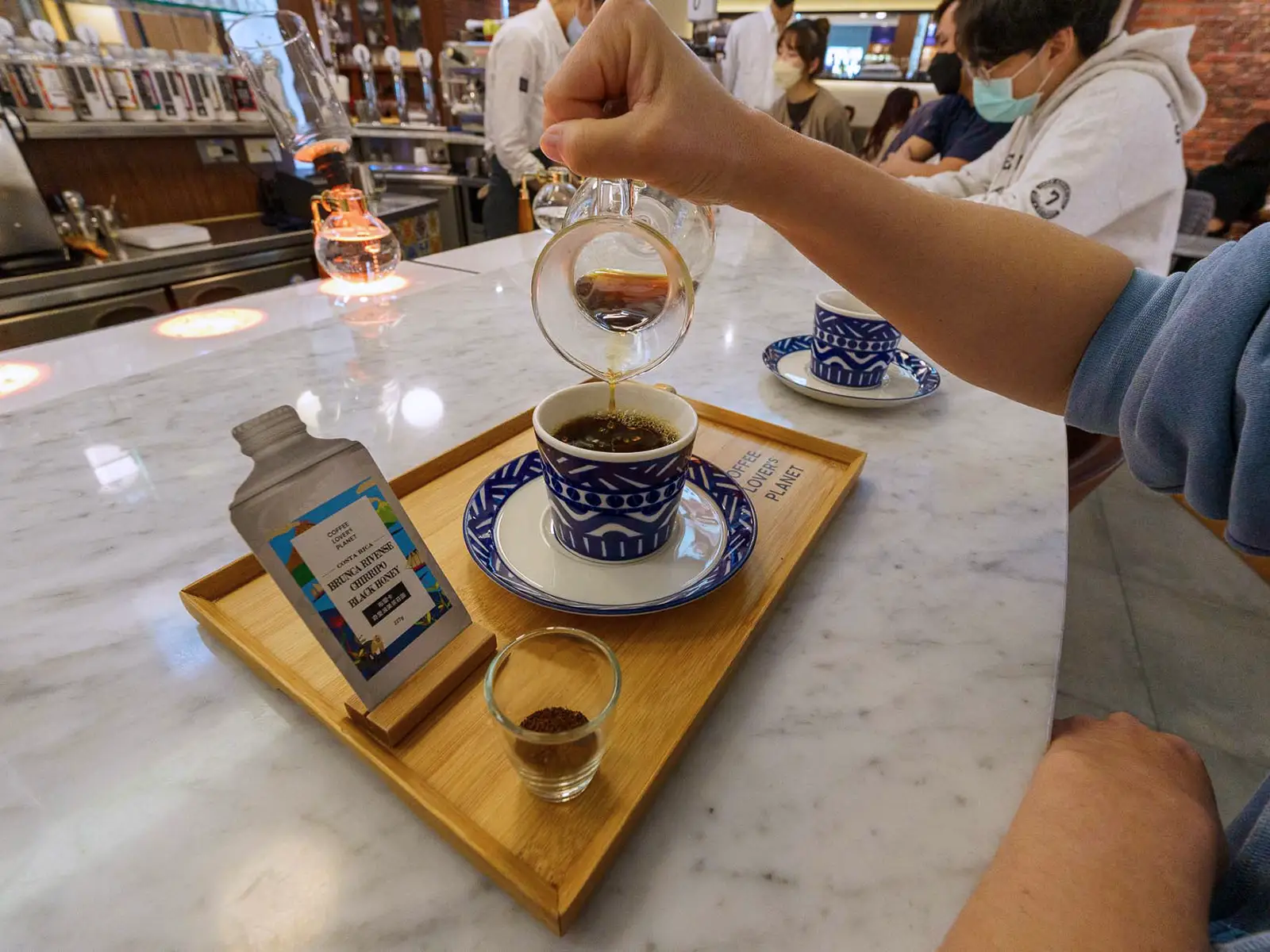 A hand pouring coffee into a cup, with a guide to flavor notes visible.