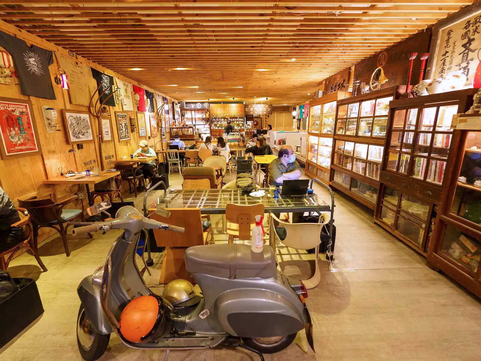 Spacious interior of Debut Cafe featuring eclectic decor and a vintage scooter.