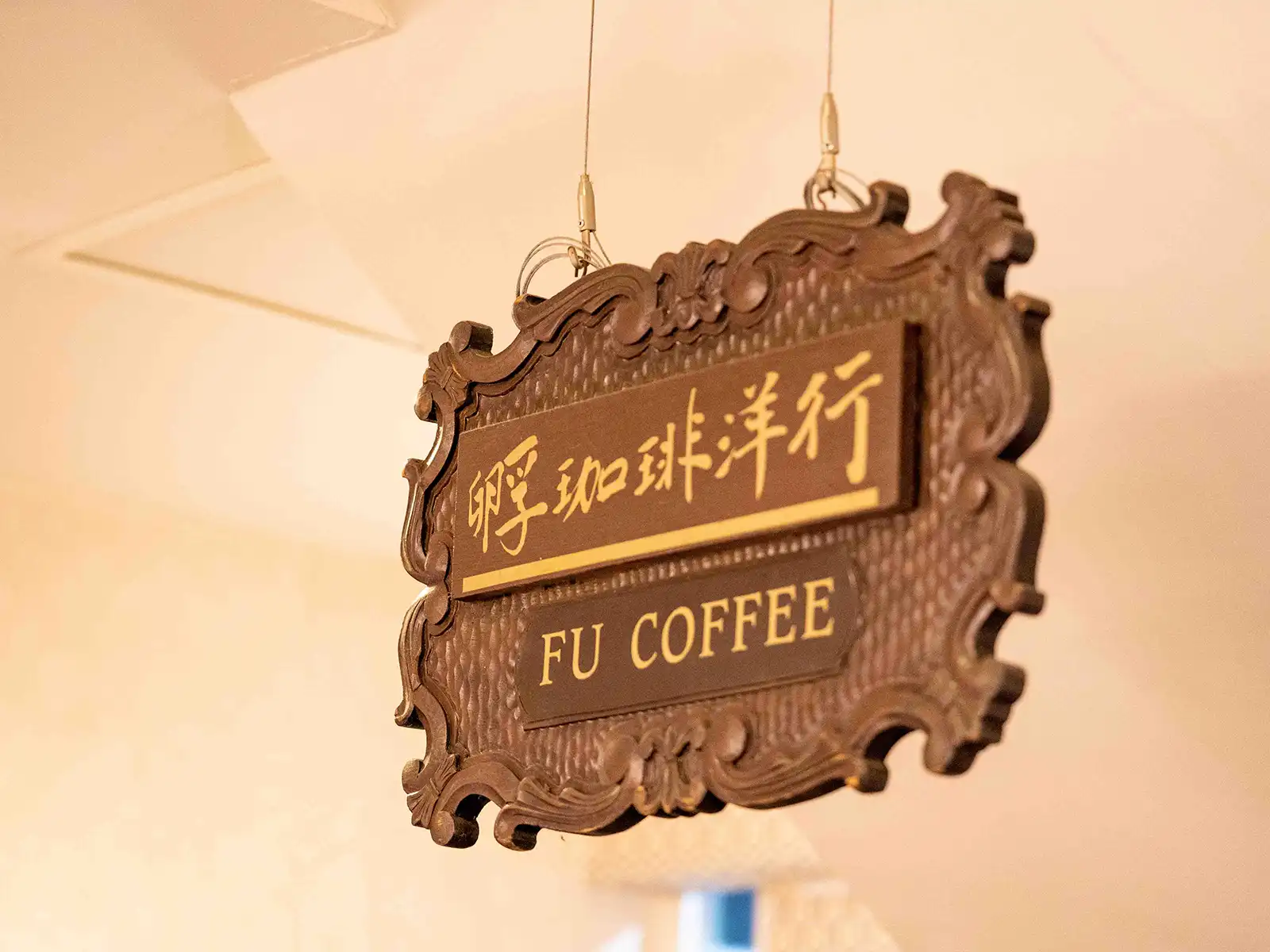 A hanging sign with Chinese characters and 'FU COFFEE' in an elegant frame.