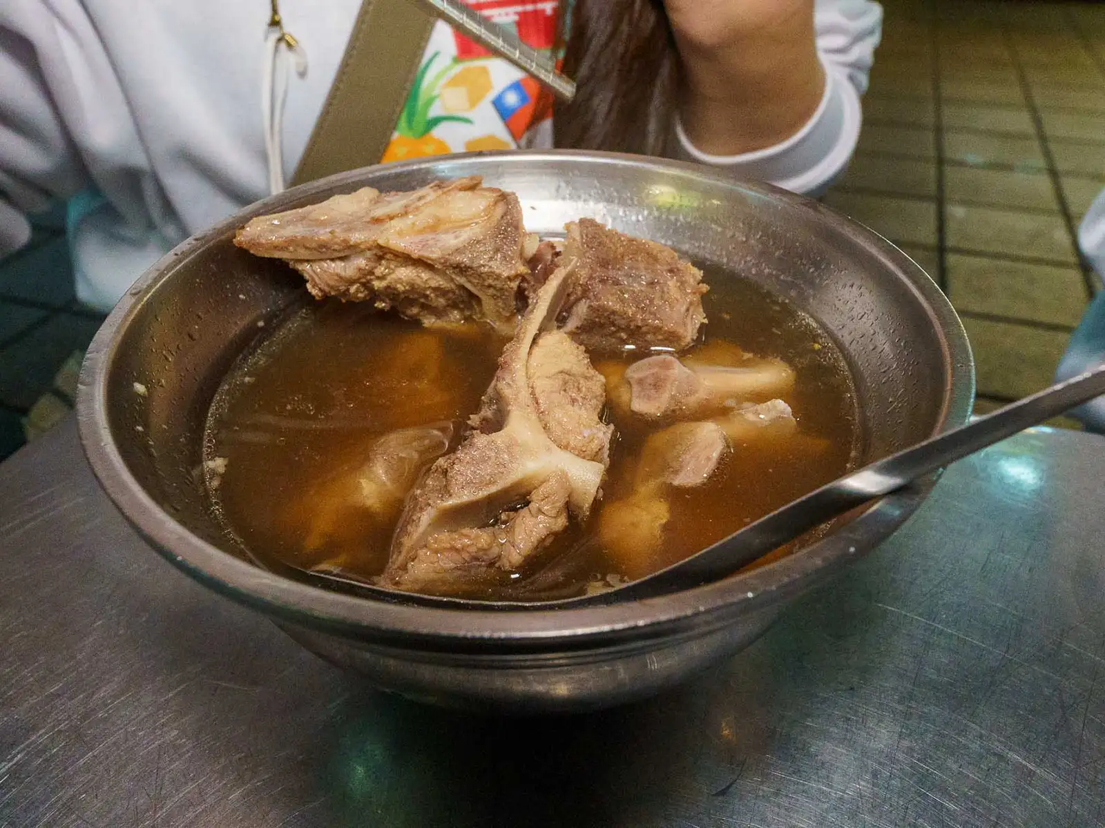 Close-up of a traditional Taiwanese pork rib soup in a metal bowl.