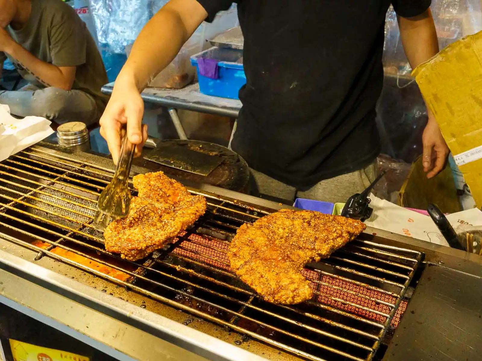 Juicy chicken cutlets on the grill at a night market.