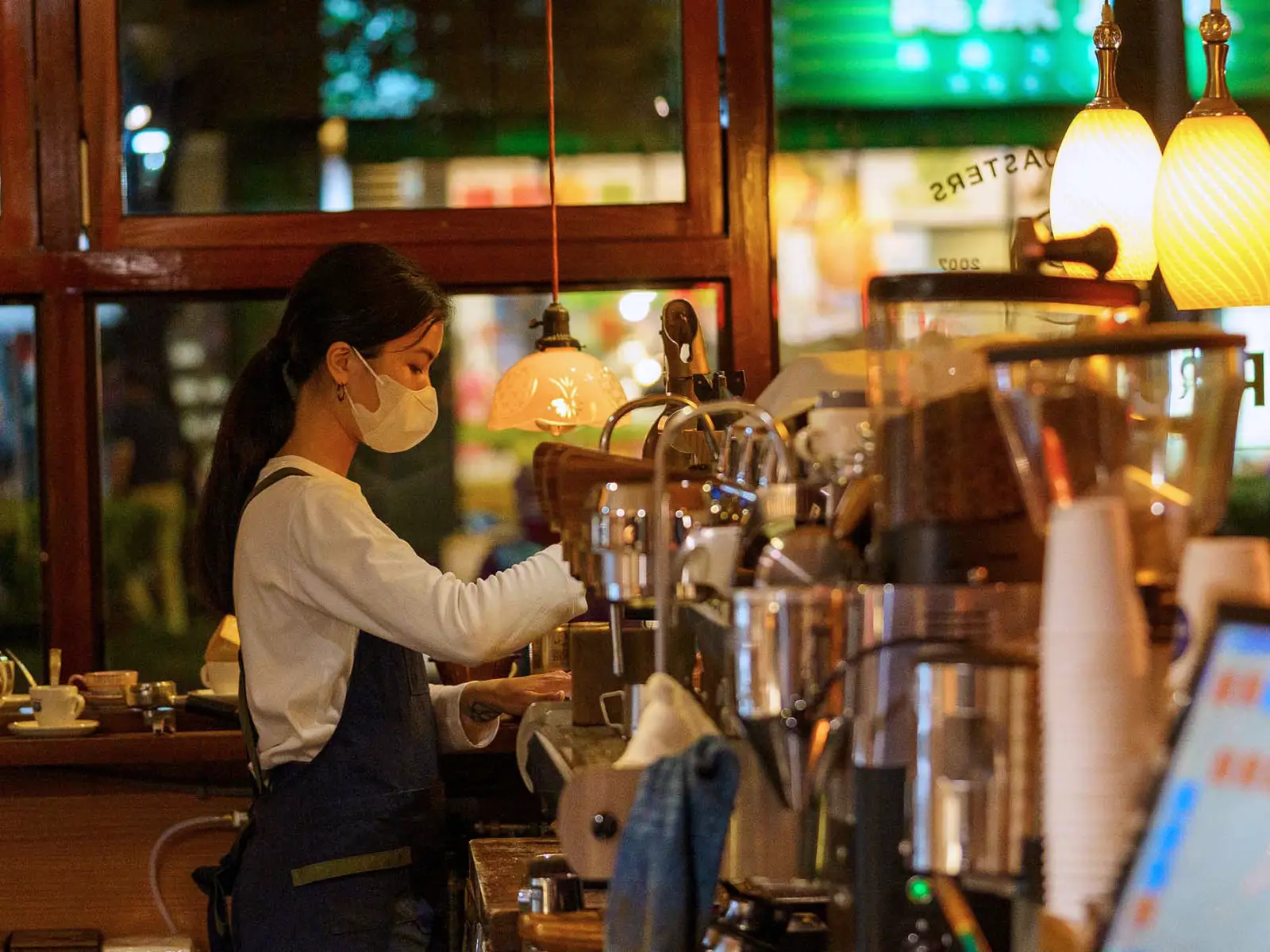 Barista at Rufous Coffee Roasters in Taipei preparing a drink wearing a mask.