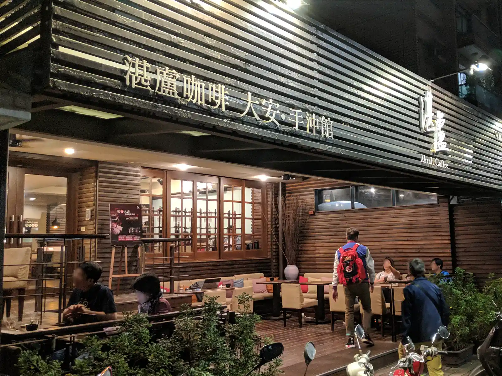 Outdoor seating at Zhanlu Coffee in Taipei with customers enjoying their evening.