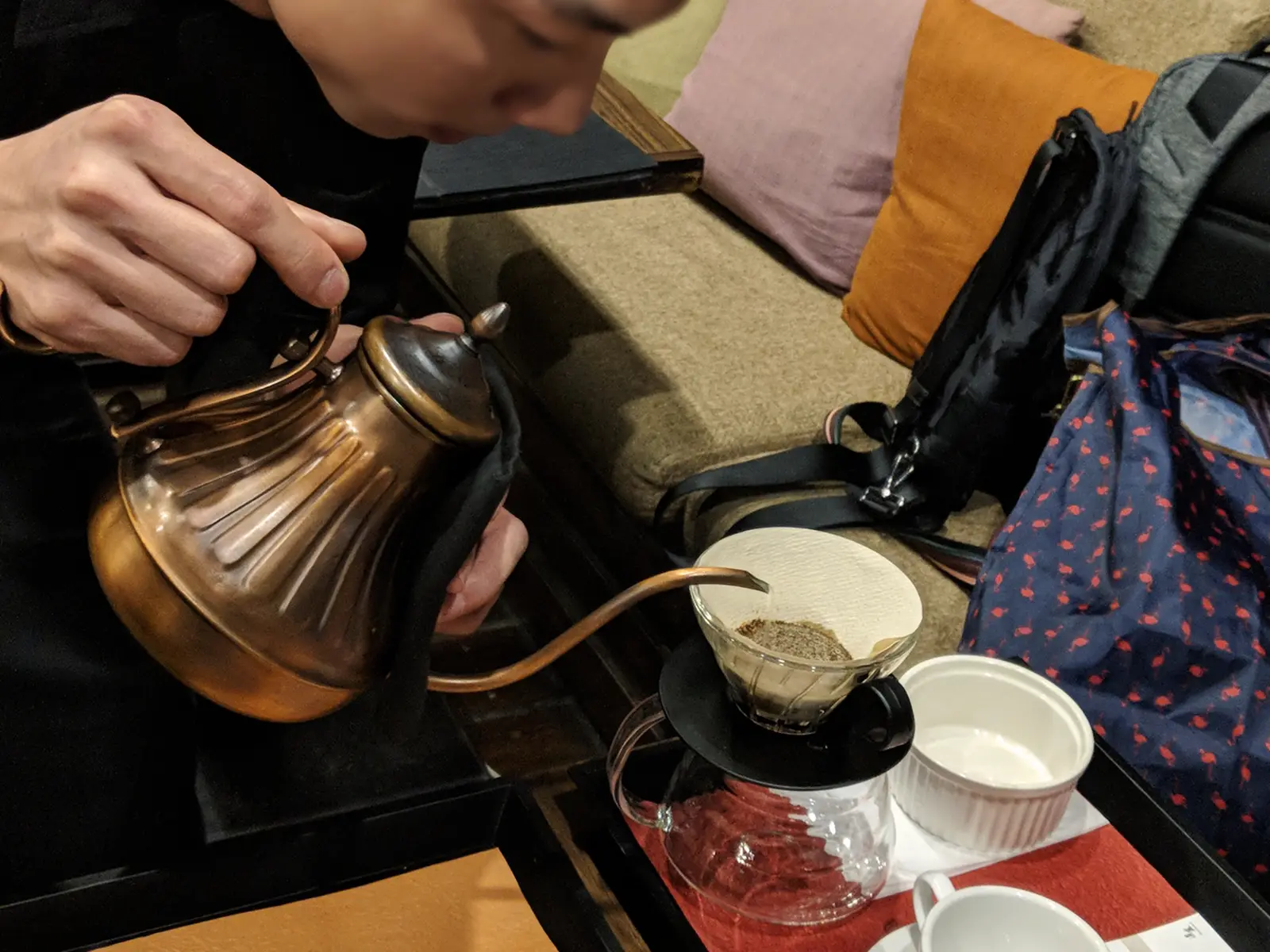 Close-up of a barista performing a pour-over at Zhanlu Coffee.