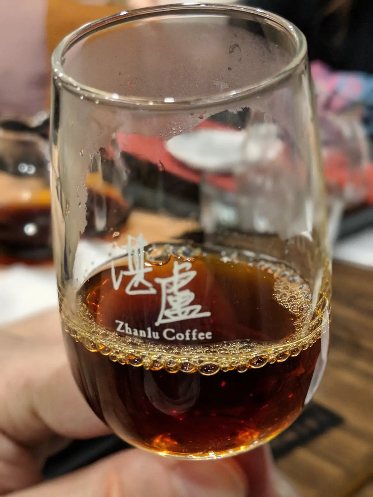 A glass of coffee at Zhanlu Coffee, highlighting the rich color and crema.